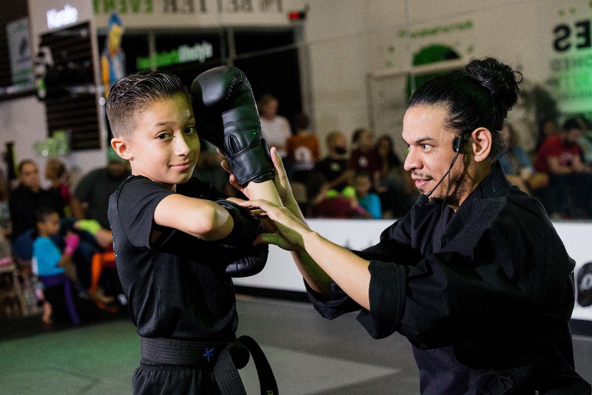Roundhouse instructor training a young student in boxing